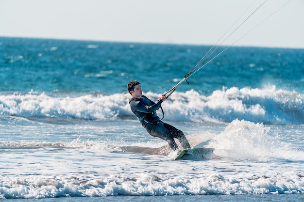 Young latino practicing kitesurfing in the pacific ocean