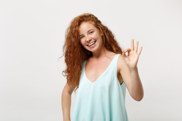 Young laughing redhead woman girl in casual light clothes posing isolated on white wall background, studio portrait. People sincere emotions lifestyle concept. Mock up copy space. Showing OK gesture.