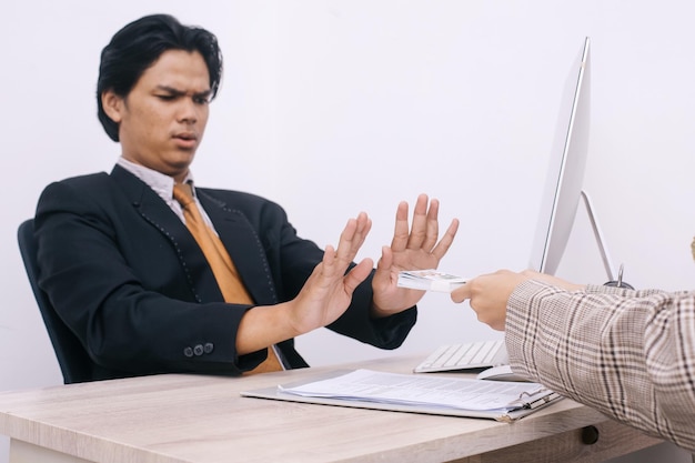 Young lawyer or politician showing stop gesture to refusing money from business people Anti bribery