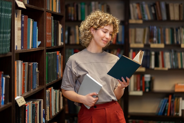 Foto giovane bibliotecario che organizza libri