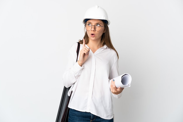 Young Lithuanian architect woman with helmet and holding blueprints isolated