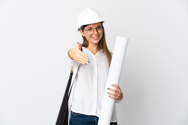 Young Lithuanian architect woman with helmet and holding blueprints isolated