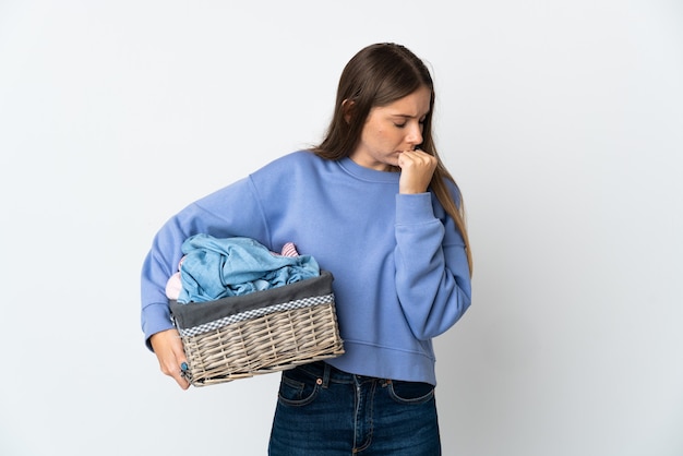 Young Lithuanian woman holding a clothes basket isolated on white background having doubts