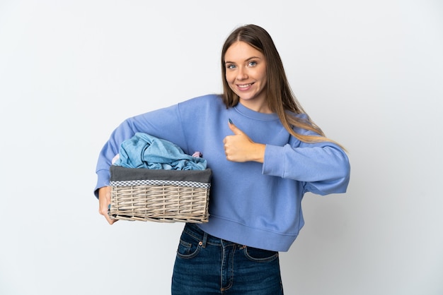 Young Lithuanian woman holding a clothes basket isolated on white wall giving a thumbs up gesture