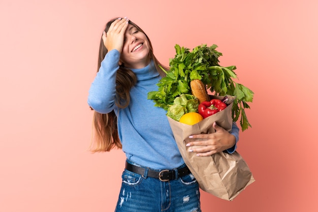 Young Lithuanian woman holding a grocery shopping bag smiling a lot