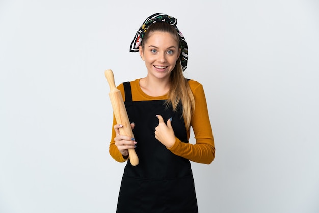 驚きの表情で白い背景に分離された麺棒を保持している若いリトアニアの女性