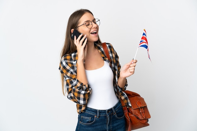 휴대 전화와 대화를 유지하는 흰색 배경에 고립 된 영국 국기를 들고 젊은 리투아니아 여자