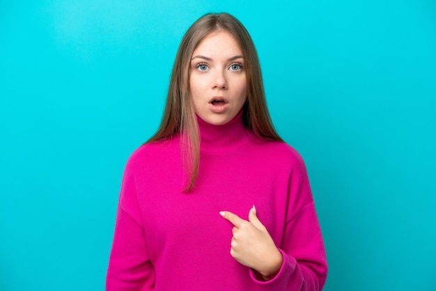 Young Lithuanian woman isolated on blue background pointing to oneself