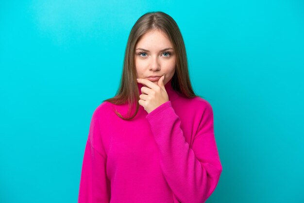 Young Lithuanian woman isolated on blue background thinking