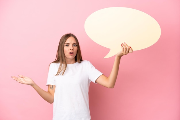 Young Lithuanian woman isolated on pink background holding an empty speech bubble with surprised expression