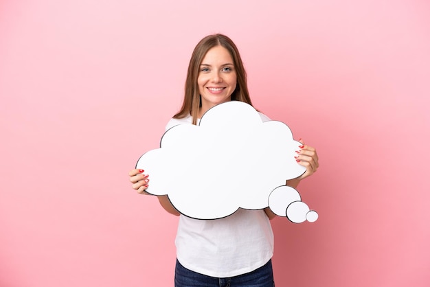 Young Lithuanian woman isolated on pink background holding a thinking speech bubble