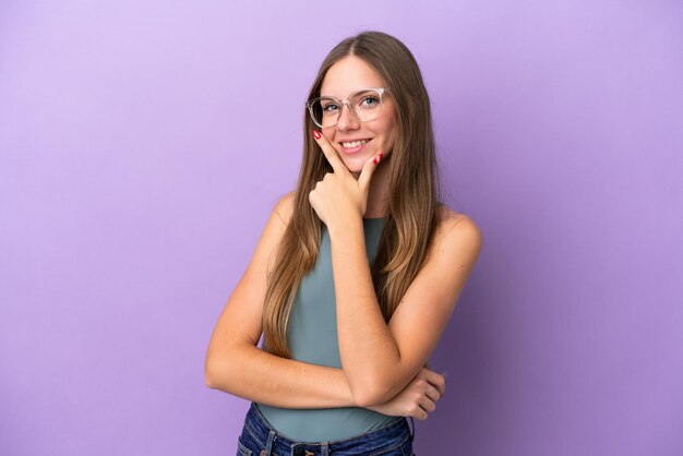 Young Lithuanian woman isolated on purple background happy and smiling