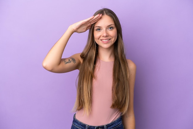 Young Lithuanian woman isolated on purple background saluting with hand with happy expression