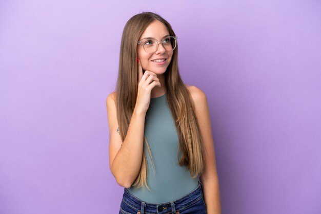 young lithuanian woman isolated on purple background thinking an idea while looking up