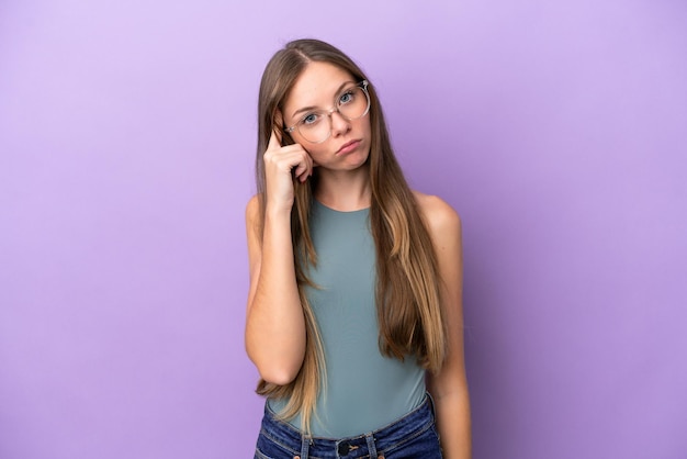 Young Lithuanian woman isolated on purple background thinking an idea