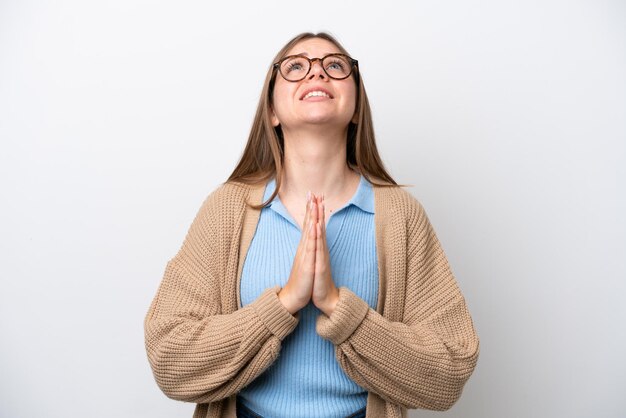 young lithuanian woman isolated on white background keeps palm together person asks for something