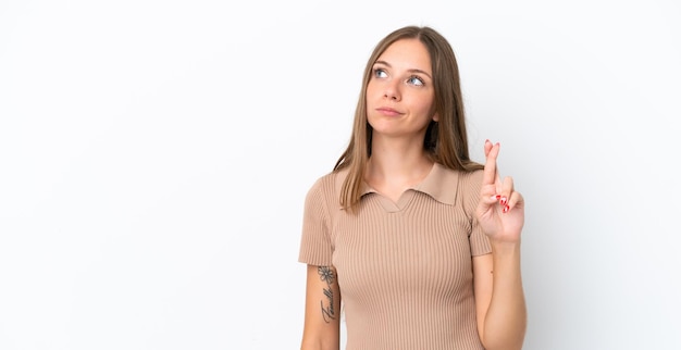 Young Lithuanian woman isolated on white background with fingers crossing and wishing the best