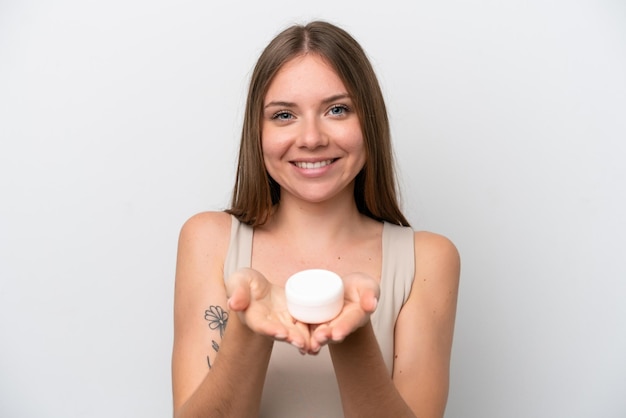 Молодая литовская женщина изолирована на белом фоне с увлажняющим кремом и предлагает его