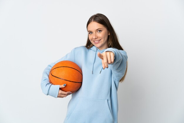 Young Lithuanian woman playing basketball isolated on white background pointing front with happy expression