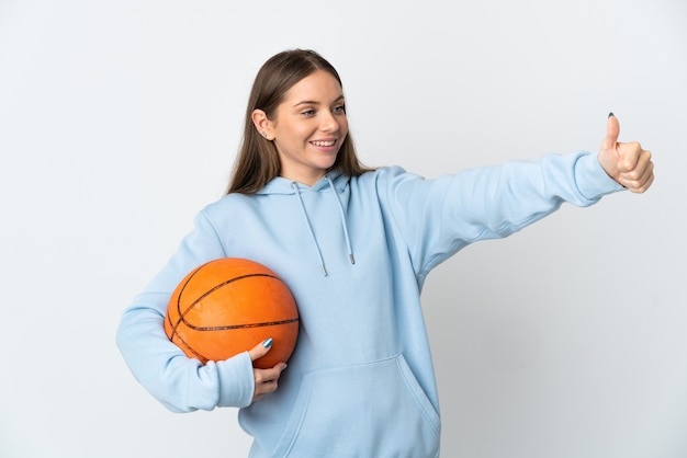 Young Lithuanian woman playing basketball isolated on white wall giving a thumbs up gesture