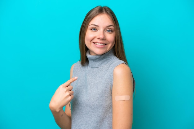 Young Lithuanian woman wearing band aids isolated on blue background with surprise facial expression