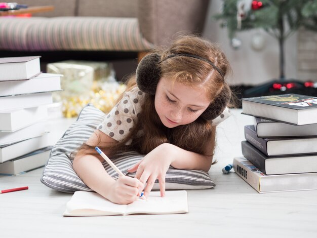 young little girl drawing book in living room