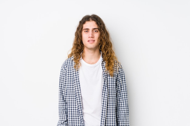 Young long hair man posing isolated happy, smiling and cheerful.