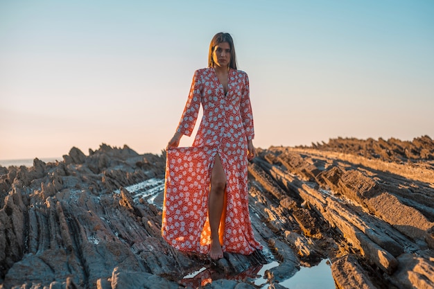 a young in a long red dress outside