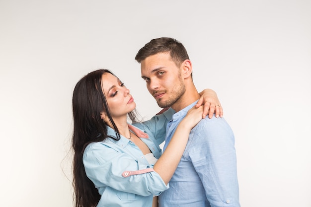 Young love couple hugging on white surface