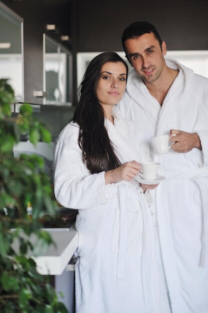 Young love couple taking fresh morning cup of coffee in the modern appartment