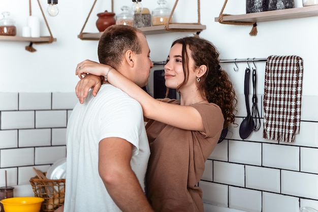 Young lovely couple hugging on kitchen counter table