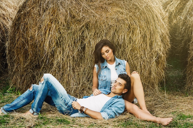 Young lovely couple is relaxing among the haystacks