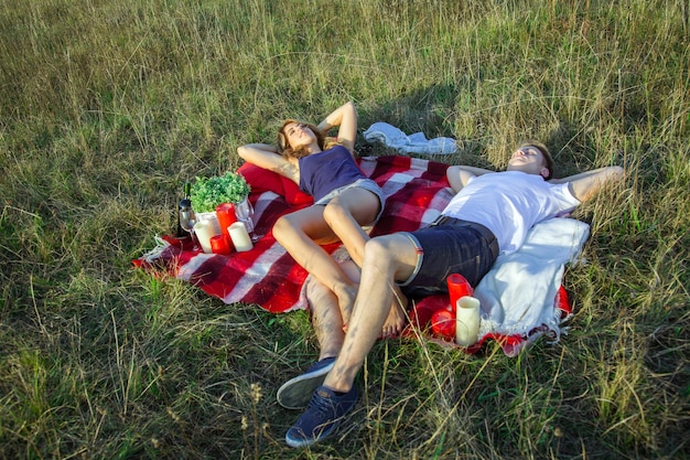 Young lovely couple lying down on summer days picnic