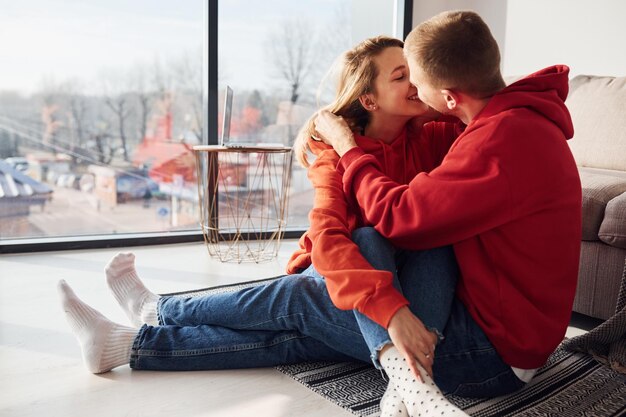 Young lovely couple together at home near window spending weekend and holidays together