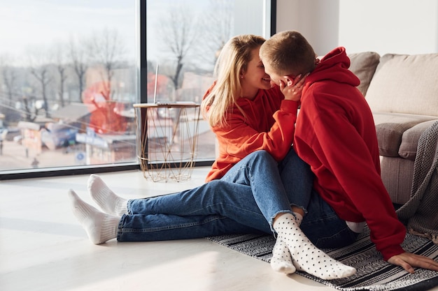 Young lovely couple together at home near window spending weekend and holidays together