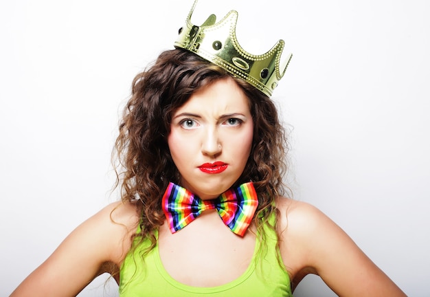 Young lovely expression woman in crown over white background