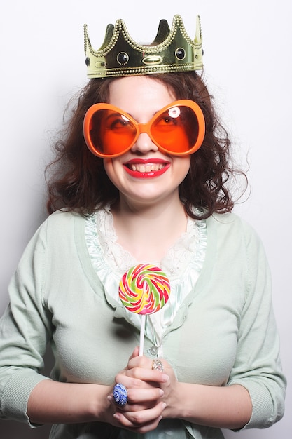 Young lovely woman in crown and funny big sunglasses