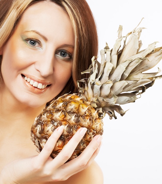 Young lovely woman with pineapple