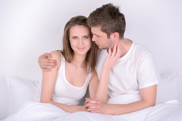 Young loving couple in a bed at home.