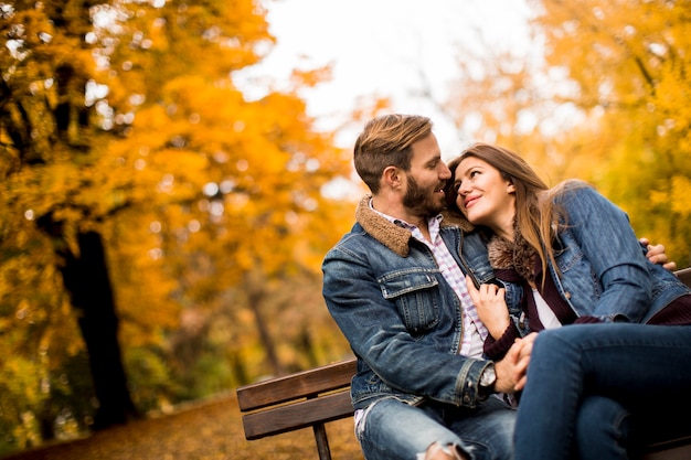 Young loving couple on a bench in autumn park