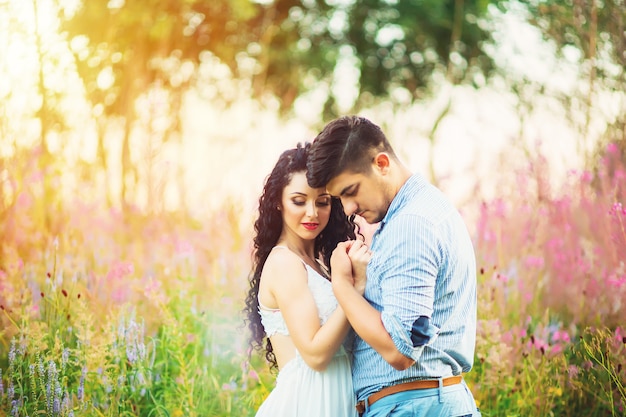 Young loving couple in a flower field