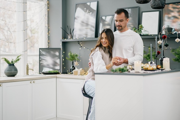 Photo young loving couple having good time at christmas morning in kitchen