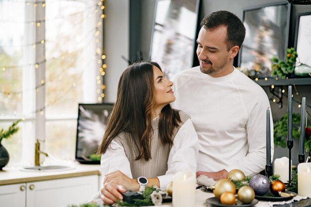 キッチンでクリスマスの朝に楽しい時間を過ごしている若い愛情のあるカップル