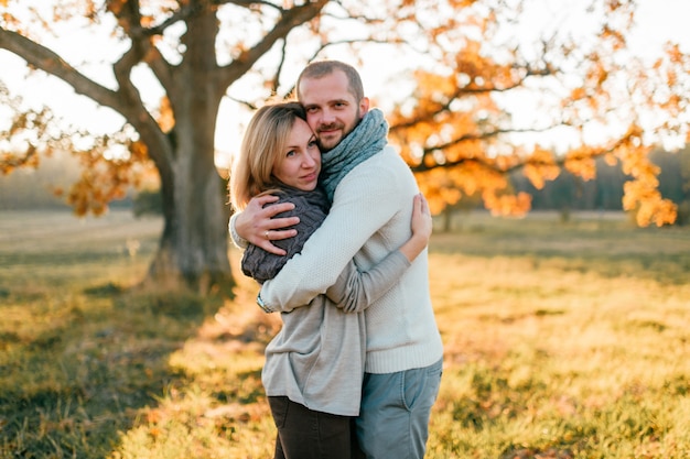 Young loving couple  hugging in autumn field at sunset