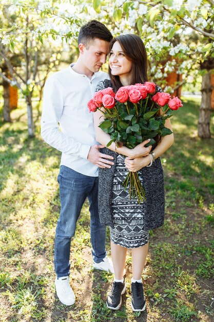 Young loving couple in love, woman holding flowers, happy and enjoy the beautiful nature