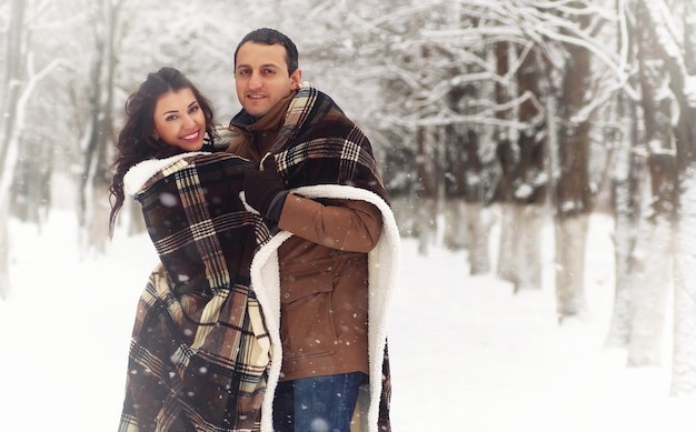 A young loving couple on a walk in a snow park