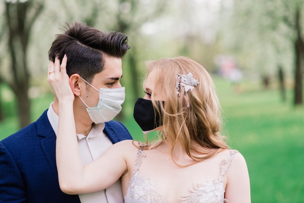 그들의 결혼 날에 얼굴 마스크를 착용하는 젊은 사랑하는 부부
