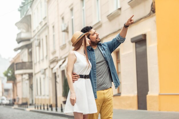 Young loving international couple of tourists contemplate architecture on a European street