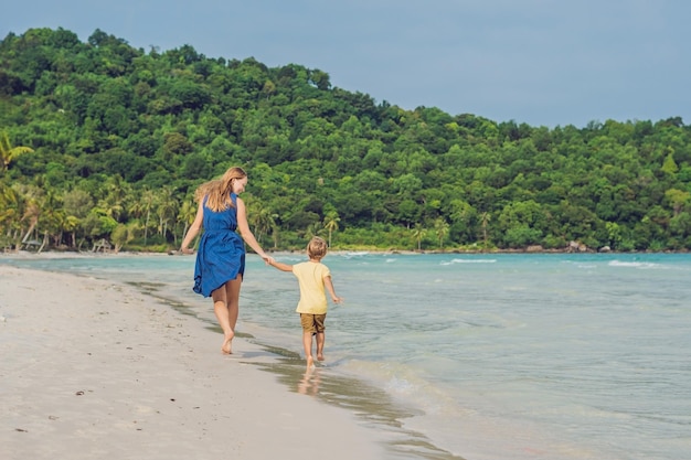 Young loving mother and her little son playing on the beach