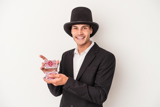 Young magician caucasian man holding a magic cards isolated on white background